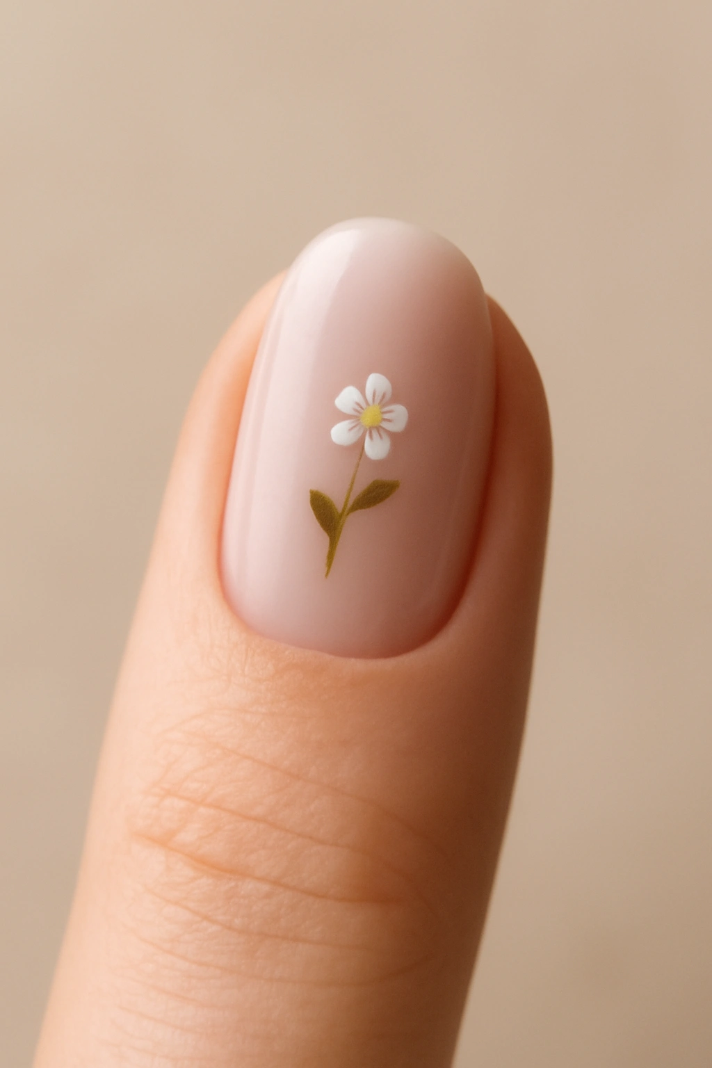 Close-up of a nude nail with a tiny dot-and-line floral accent