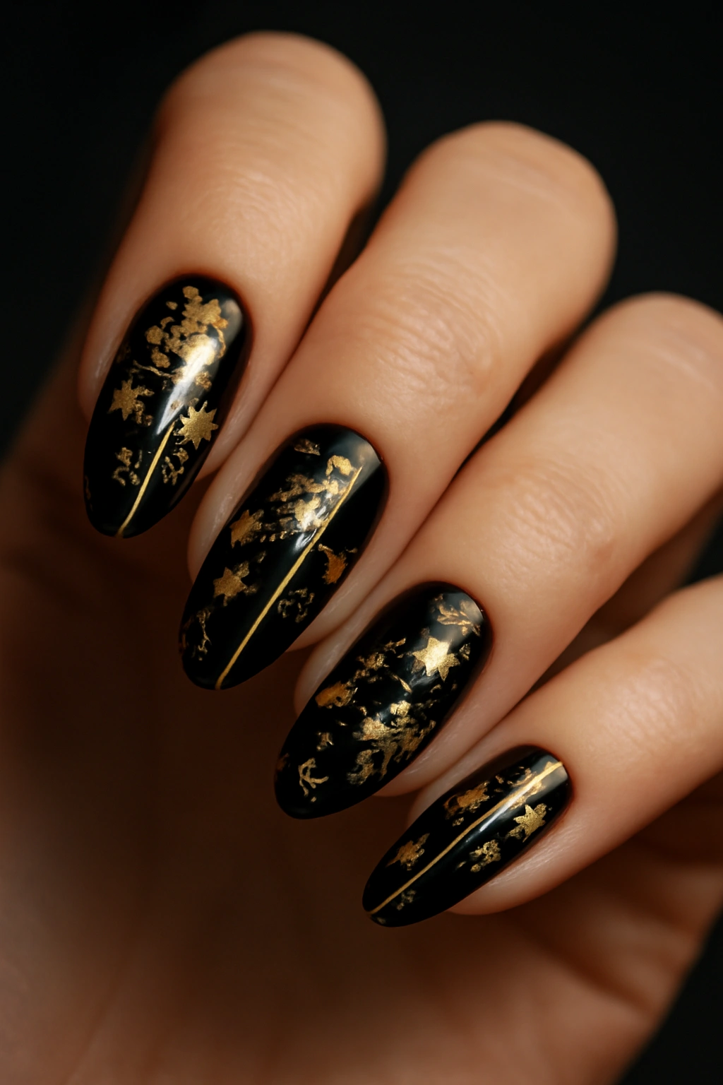 Nails with black base and gold foil accents