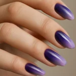 Close-up of ombre purple nails transitioning from dark to light