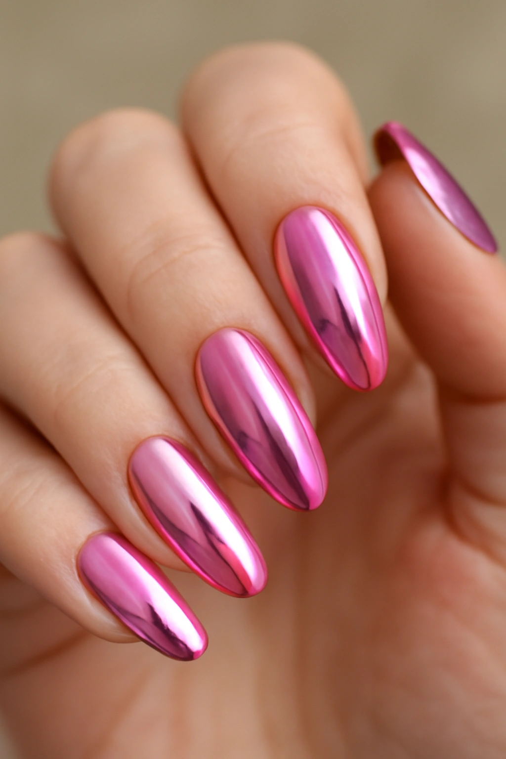 Close-up of pink chrome nails with pastel to hot fuchsia sheen