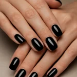 Close-up of ten glossy black nails with a flawless high-shine finish.
